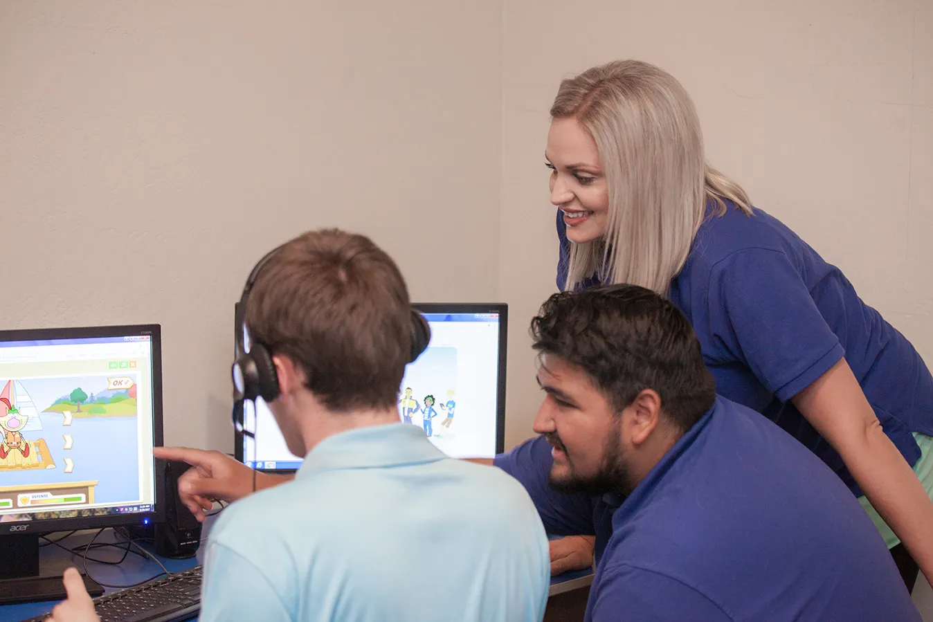 Teacher working one-on-one with a student at a computer at ASCEND school