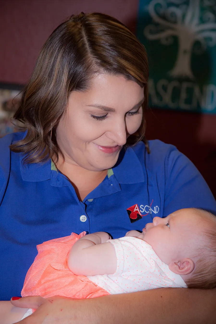 An ASCEND team member holding a child, part of the ASCEND family community